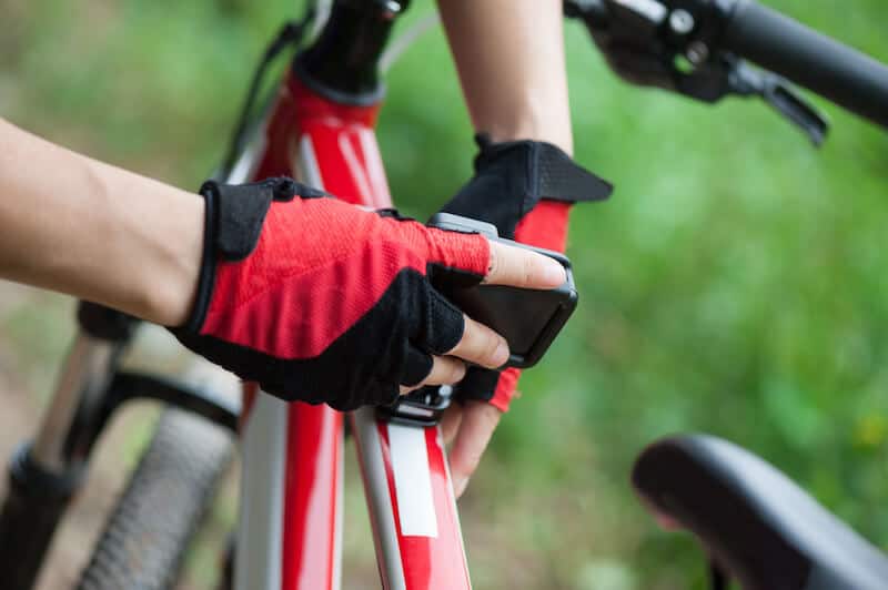 Hands mounting action camera on mountain bike