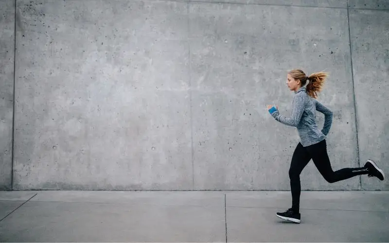 Female Running Along Concrete Wall