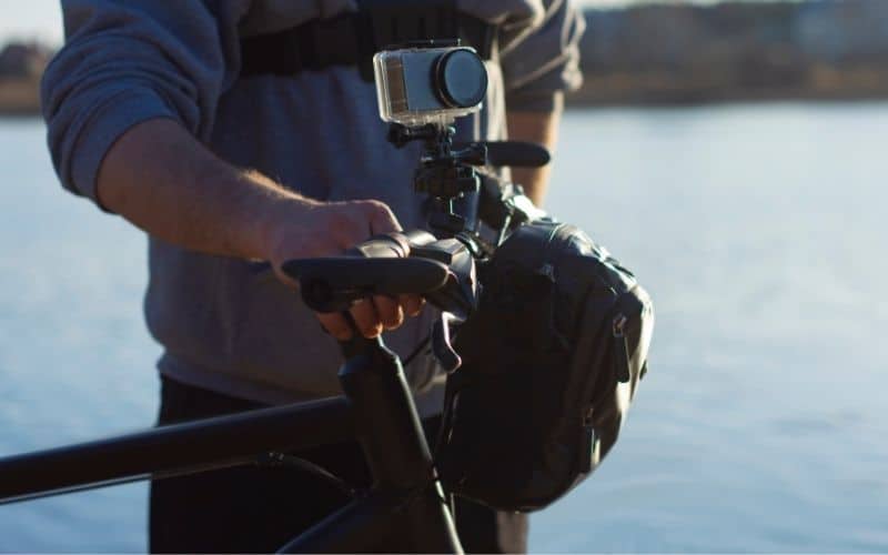 Cyclist with a bike and an action camera with a camera bag