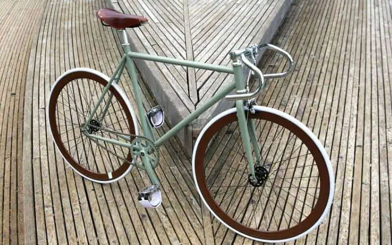 Green fixie bike with brown and white wheels