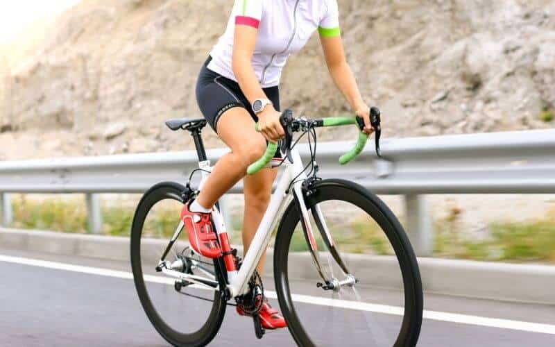 Female Road Cyclist with red road bike shoes