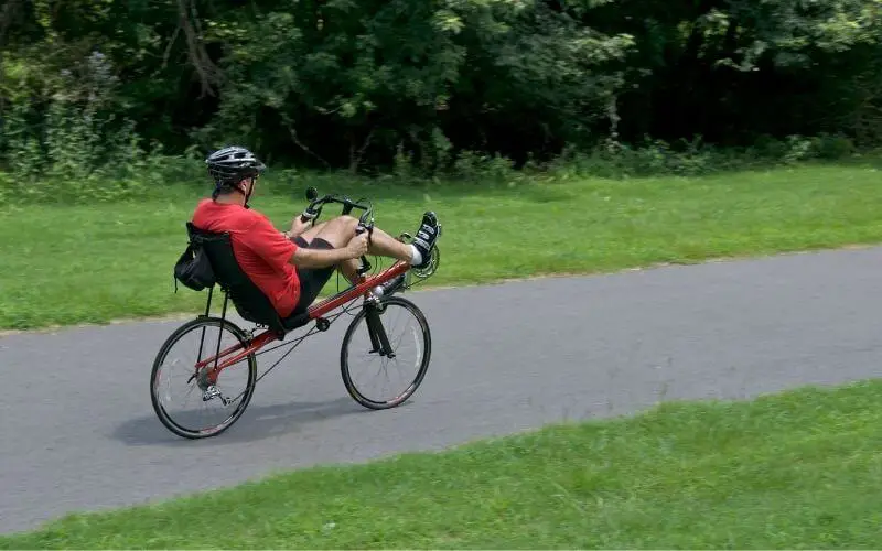 Man riding a red recumbent bike