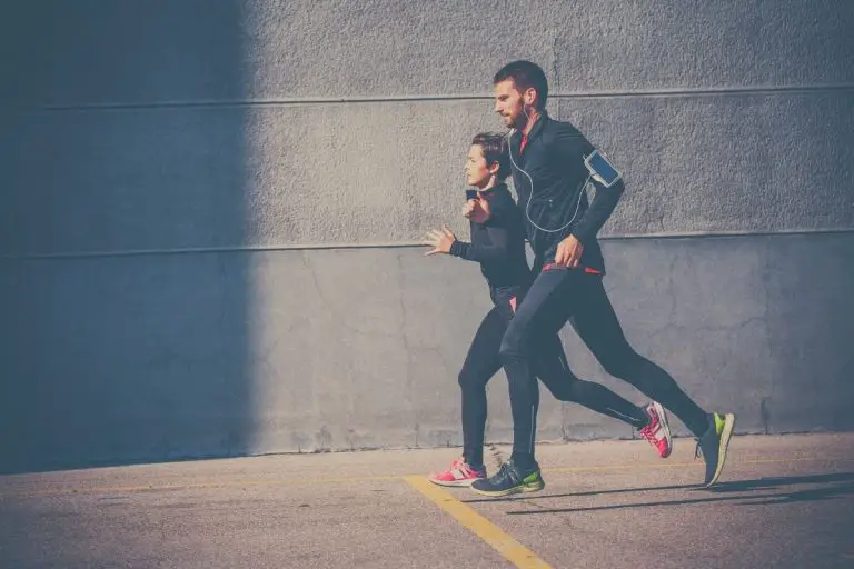 Woman and man running along the pavement