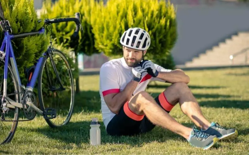 Cyclist sitting down and taking a break