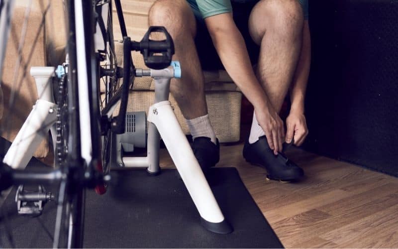 Man putting cycling shoes on to go indoor cycling
