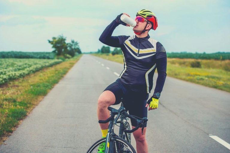 Cyclist drinking from a white water bottle