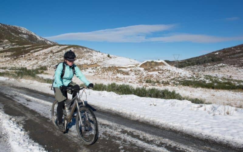 Woman mountain biking through the snow