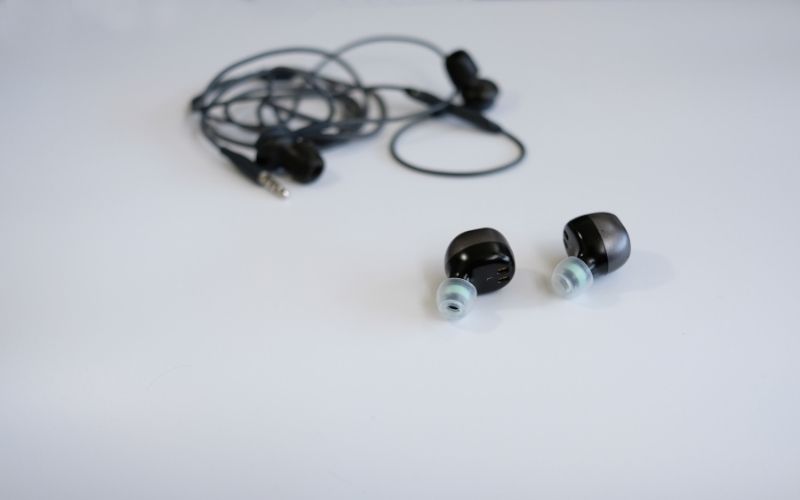 True wireless headphones in front of wired headphones