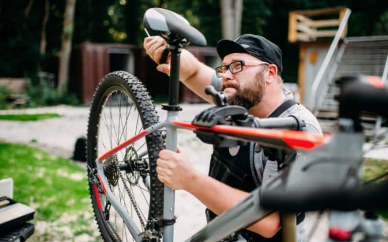 Man tightening bike seat post