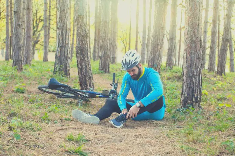 Injured cyclist holding his foot