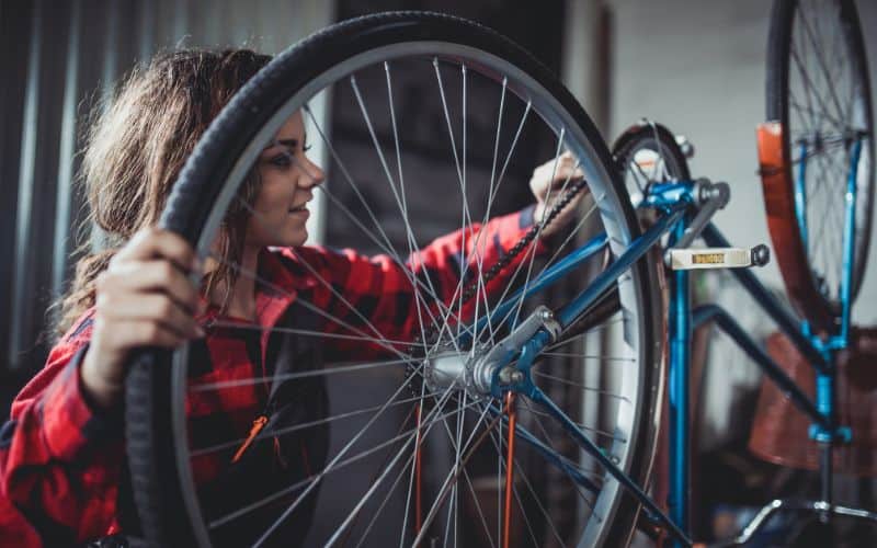 Woman fixing a bike
