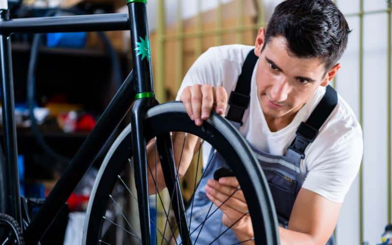 Bike mechanic fixing wheel
