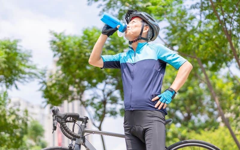 Cyclist drinking from bottle in hot weather