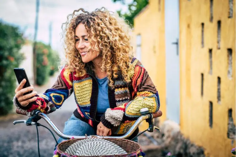 Woman sitting on a bike with her phone