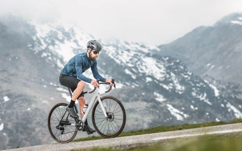 Cyclist facing steep uphill climb on road bike