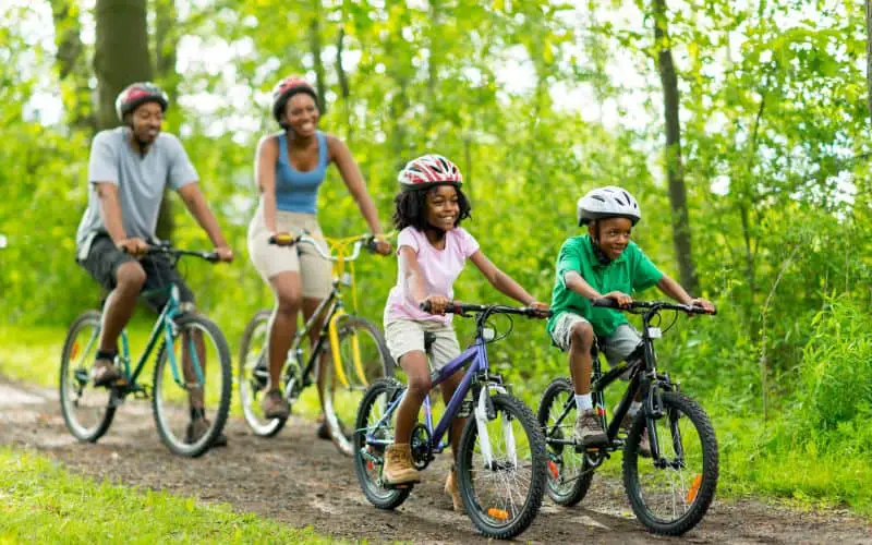 Family of four cycling in the park